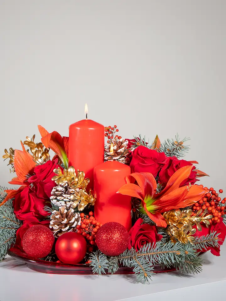 Centrotavola natalizio rosso di rose e amaryllis e 2 candele rosse close up